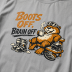 Close-up of a relaxed marmot holding a steaming mug beside ski boots and a helmet with the words “Boots Off, Brain Off.”