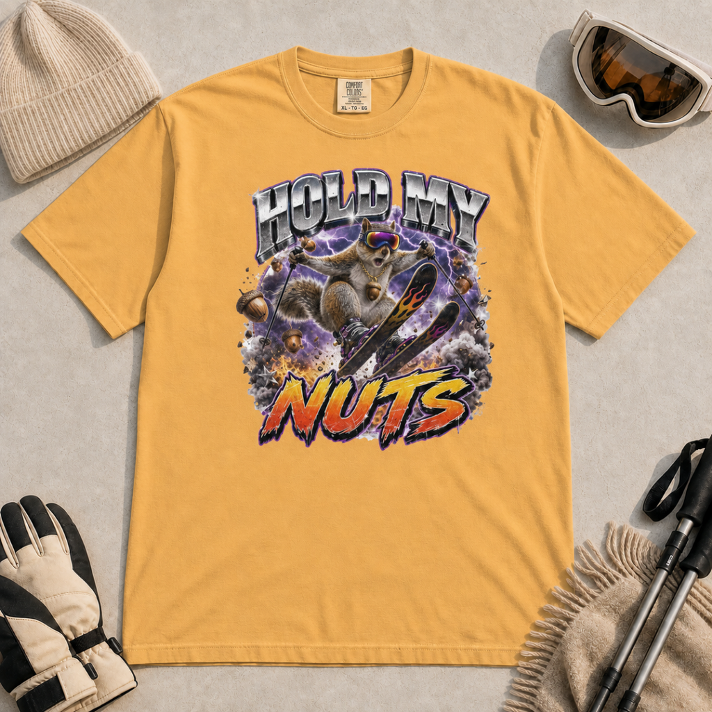 Mustard yellow t-shirt featuring a squirrel performing an aerial ski trick beneath the words “Hold My Nuts.”