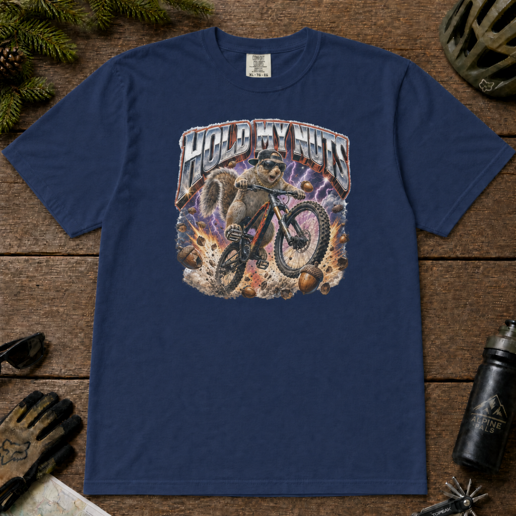 Navy blue t-shirt featuring a squirrel mountain biking through flying acorns beneath the words “Hold My Nuts.”