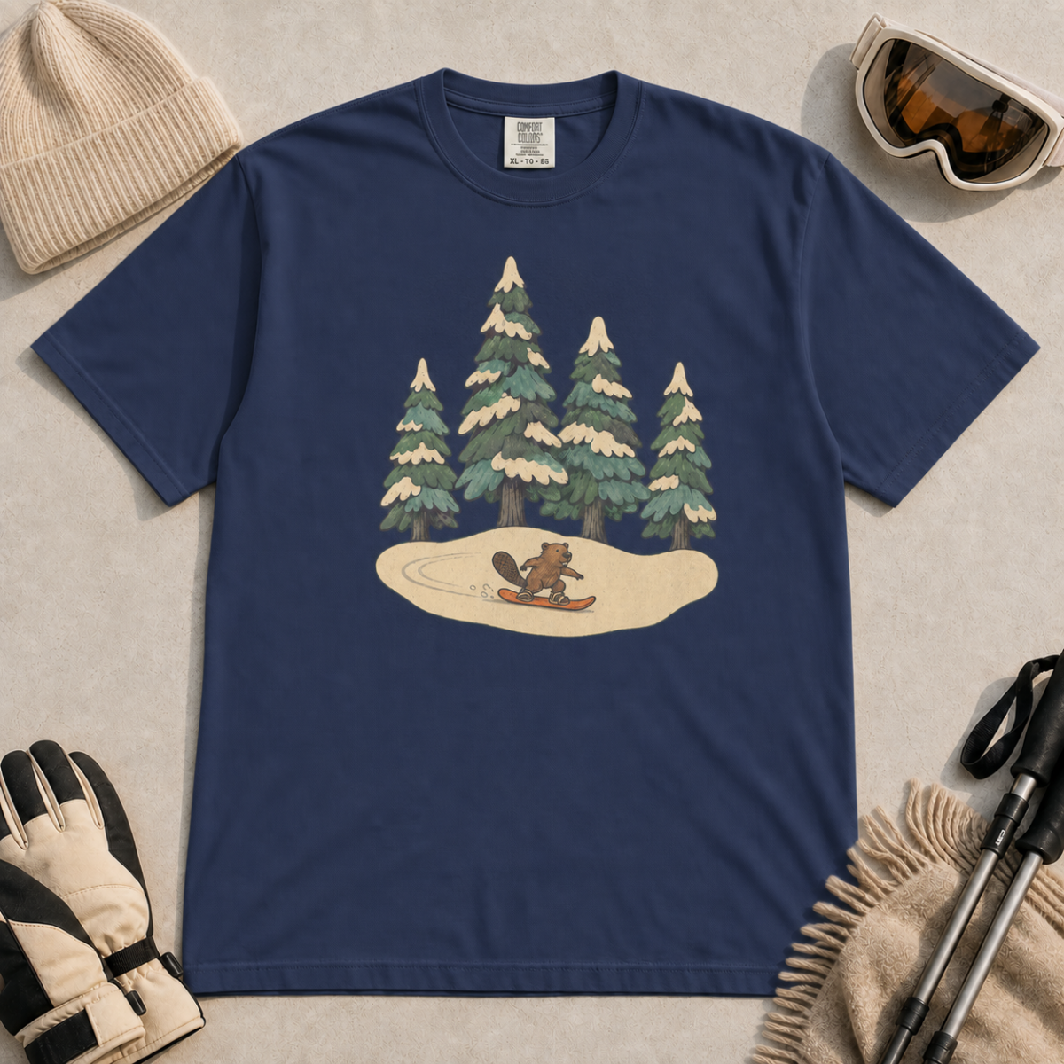 Navy blue t-shirt featuring a small beaver snowboarding beneath four snow-covered pine trees.