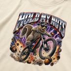 Close-up of a bold squirrel mountain biking design with lightning, flying acorns, and the words “Hold My Nuts” on a charcoal ivory white t-shirt.