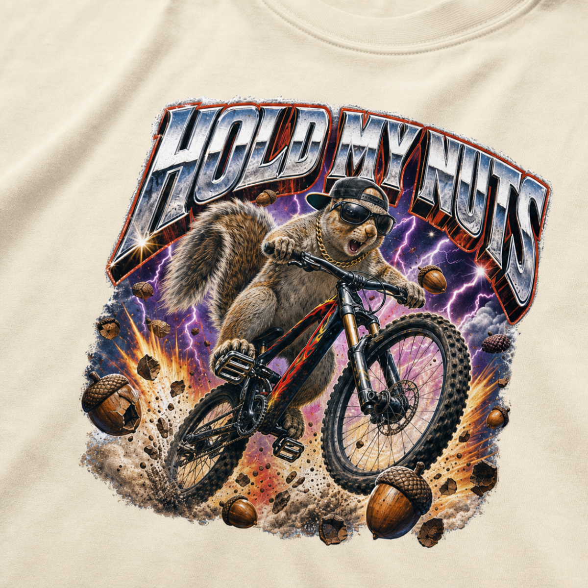 Close-up of a bold squirrel mountain biking design with lightning, flying acorns, and the words “Hold My Nuts” on a charcoal ivory white t-shirt.