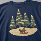 Close-up of a small beaver snowboarding through a snowy evergreen forest on a navy blue t-shirt.