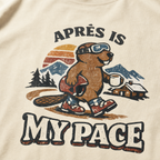 Close-up of a vintage beaver après-ski design with mountains, a cabin, and the words “Après Is My Pace” on an ivory white t-shirt.