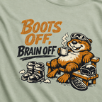 Close-up of a relaxed marmot holding a steaming mug beside ski boots and a helmet with the words “Boots Off, Brain Off.”