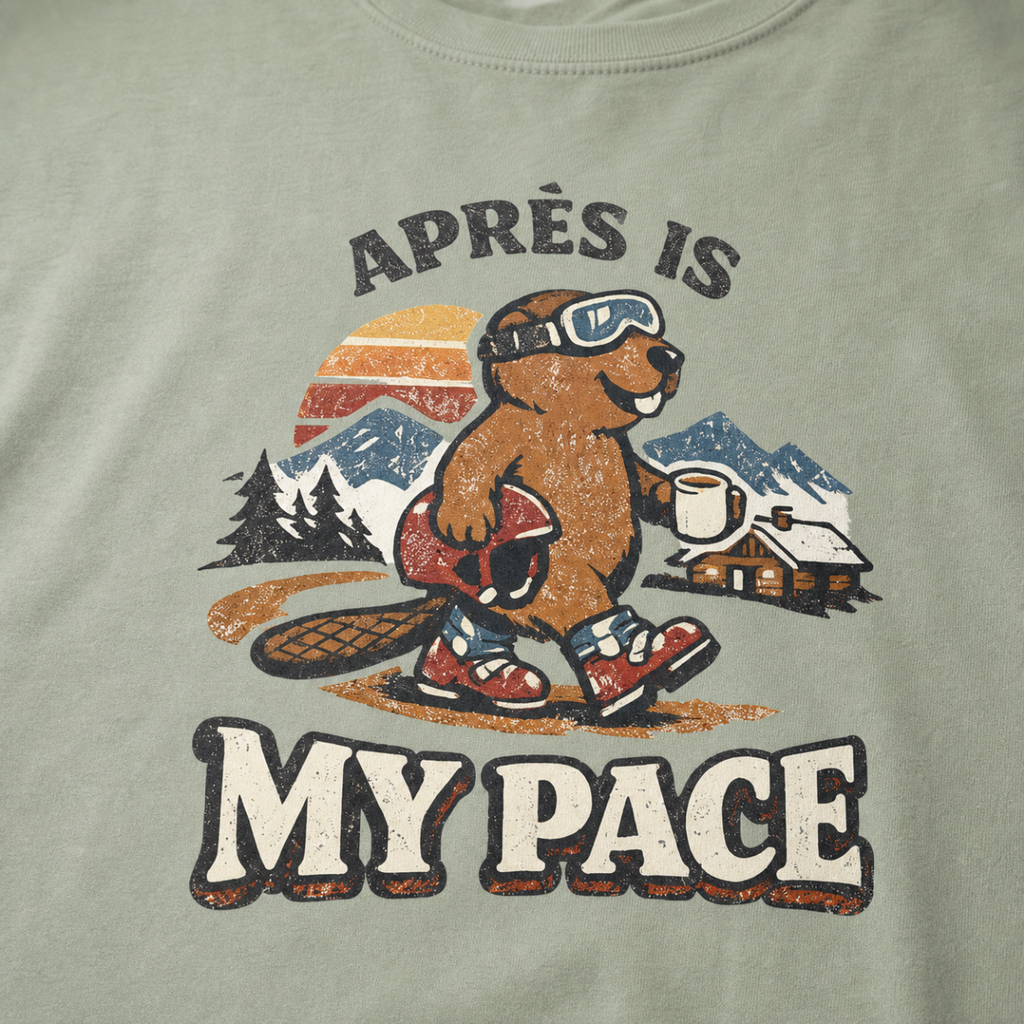 Close-up of a vintage beaver après-ski design with mountains, a cabin, and the words “Après Is My Pace” on a bay green t-shirt.