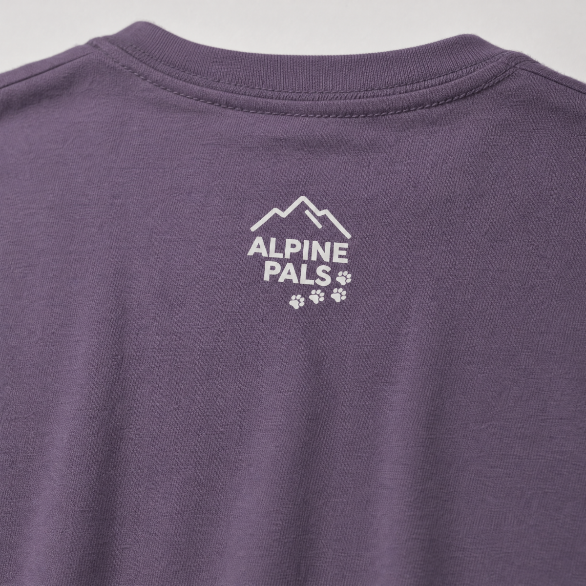 Purple shirt with 'Alpine Pals' logo on a light gray background