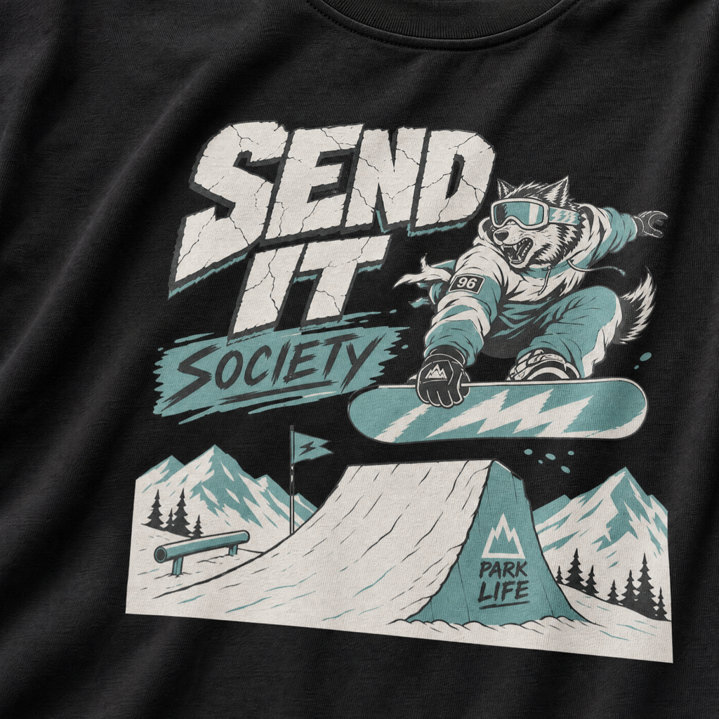 Black t-shirt with a graphic of a snowboarder and 'Send It Society' text on a mountain background.