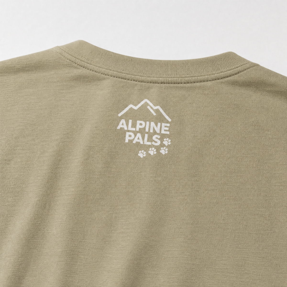 Close-up of a Khaki shirt with 'Alpine Pals' logo on a white background