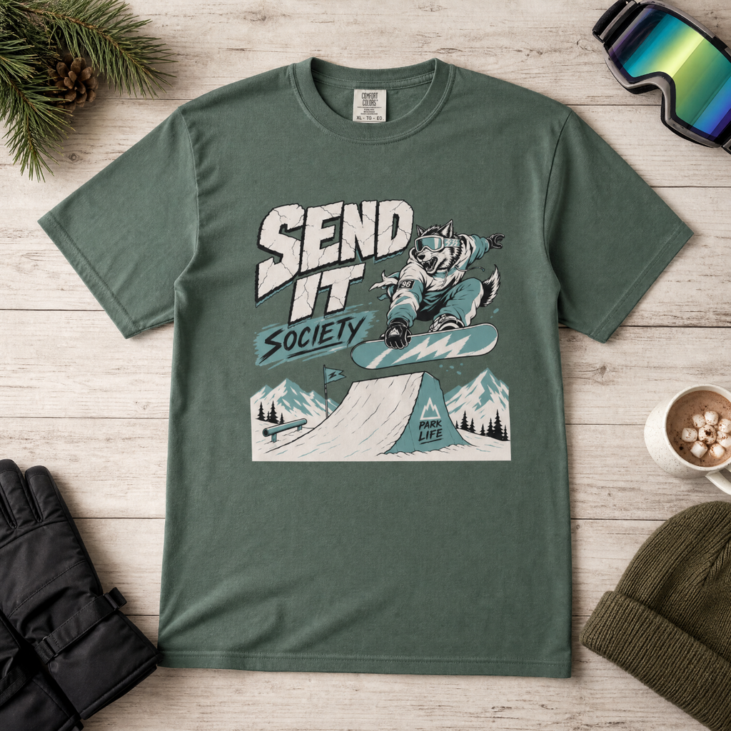 Blue spruce green t-shirt with graphic design featuring a snowboarder and text on a wooden surface.
