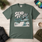 Blue spruce green t-shirt with graphic design featuring a snowboarder and text on a wooden surface.