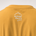 Mustard yellow shirt with 'Alpine Pals' logo on a white background