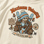 T-shirt with a sloth character holding skis and a coffee cup, featuring text and graphics on an ivory background.