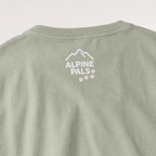 Bay green t-shirt with 'Alpine Pals' logo on a light gray background