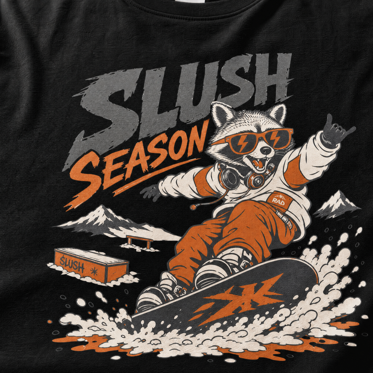 Black t-shirt with a graphic of a raccoon snowboarding and 'Slush Season' text.