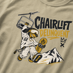 T-shirt with a graphic of a snowboarding dog holding a ski lift and the text 'Chairlift Delinquent' on a beige background.