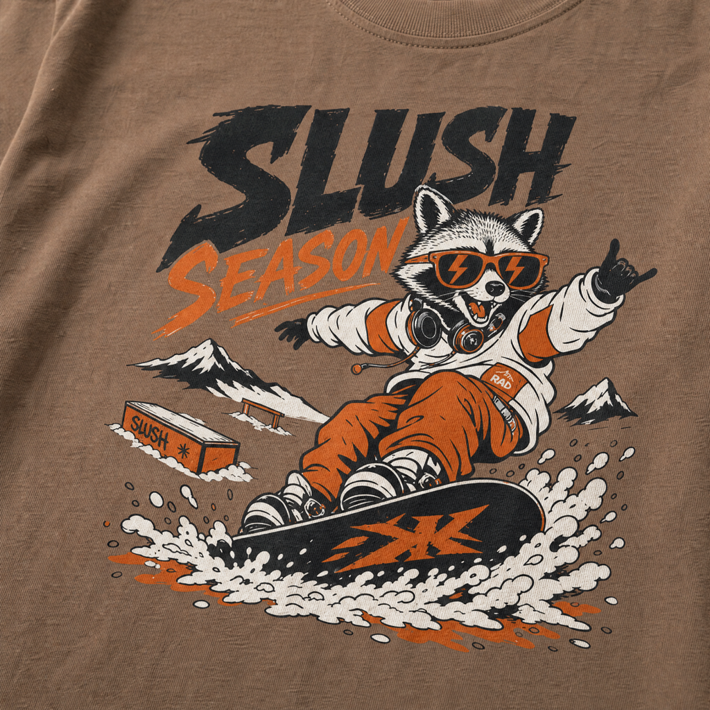 T-shirt with a raccoon snowboarding graphic and 'Slush Season' text on an Espresso brown background