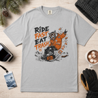 Granite gray t-shirt with a graphic design featuring a bear and text on a wooden surface with accessories.