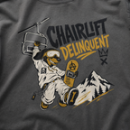 Pepper gray t-shirt with a graphic of a dog on skis, chairlift, and mountain, with 'Chairlift Delinquent' text.