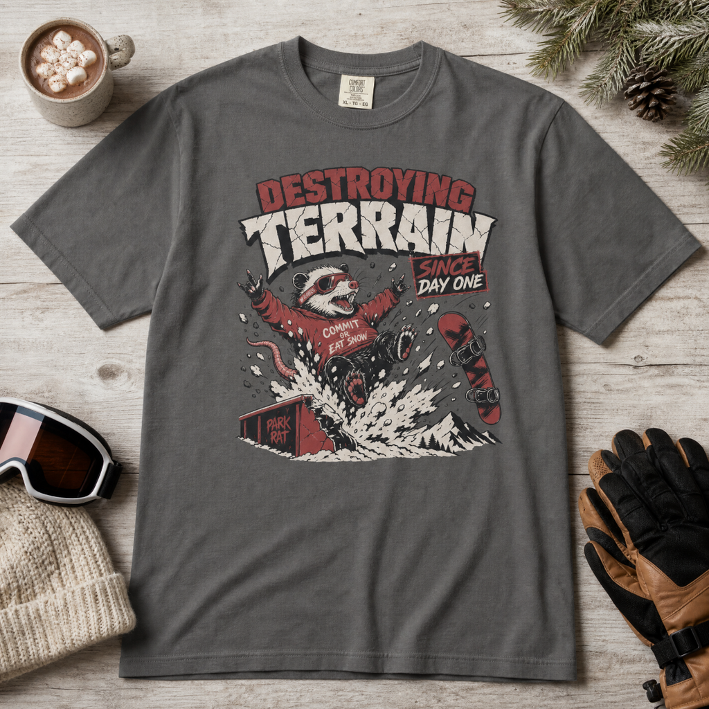 Pepper gray t-shirt with graphic design on a wooden surface with accessories.
