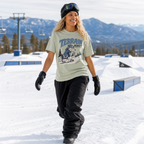 Person wearing a 'Terrain Addict' t-shirt in a snowy landscape with mountains in the background.