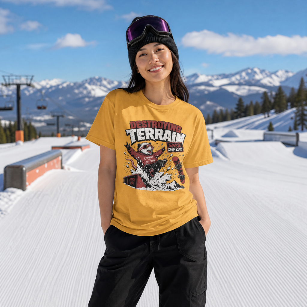 Person wearing a Mustard yellow t-shirt with a graphic design in a snowy mountain setting