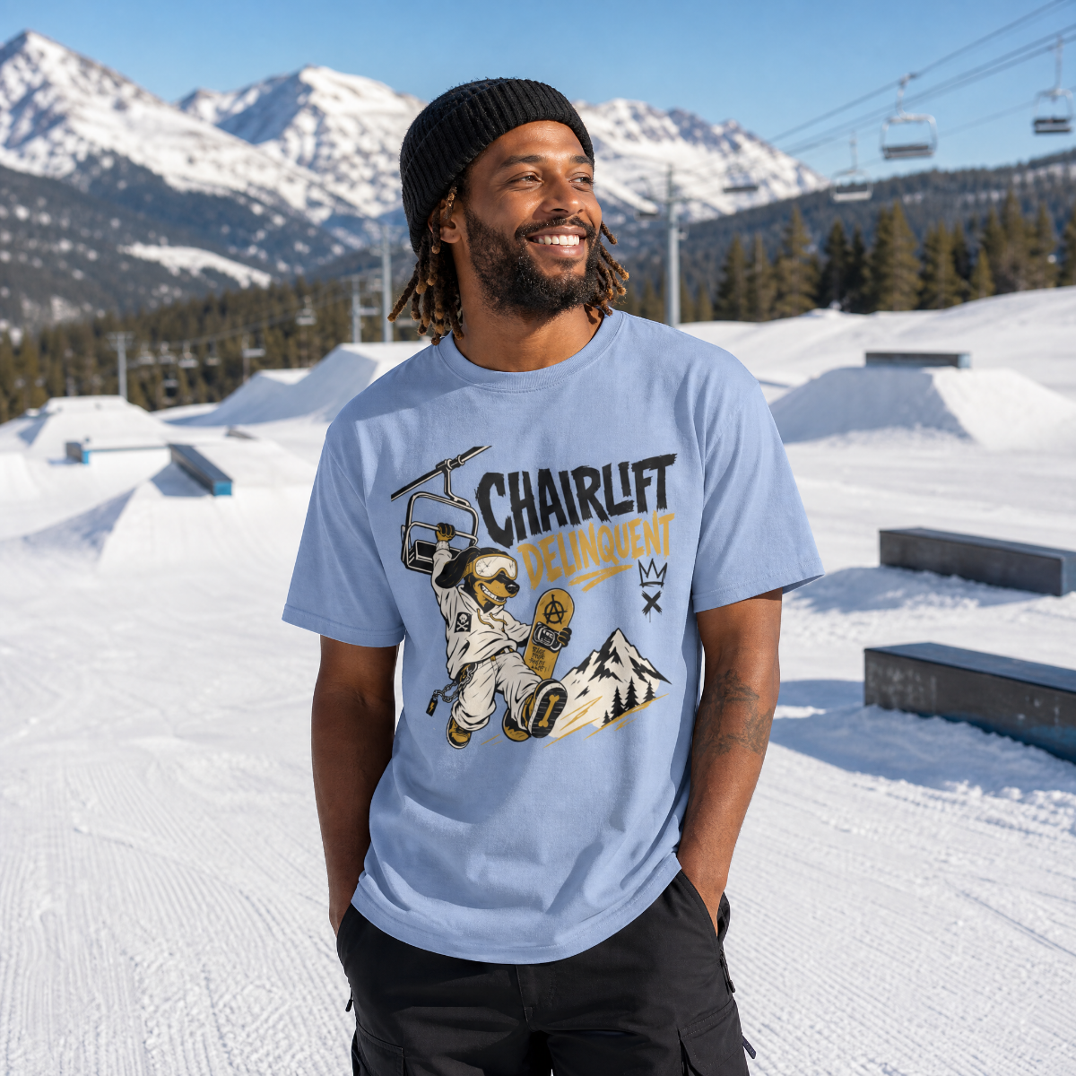 Person wearing a washed denim blue t-shirt with a graphic design in a snowy mountain setting