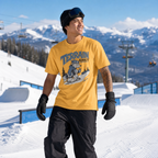 Person wearing a Mustard yellow 'Terrain Addict' t-shirt in a snowy mountain setting