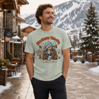 Man wearing a t-shirt with a sloth graphic in a snowy mountain village setting