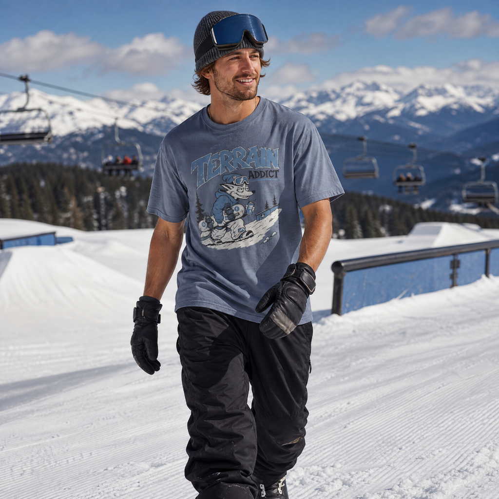 Man in ski gear standing on a snowy slope with mountains in the background