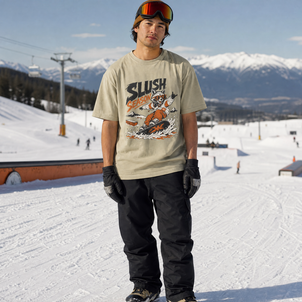 Person wearing a 'Slush Season' t-shirt in a snowy landscape with mountains in the background