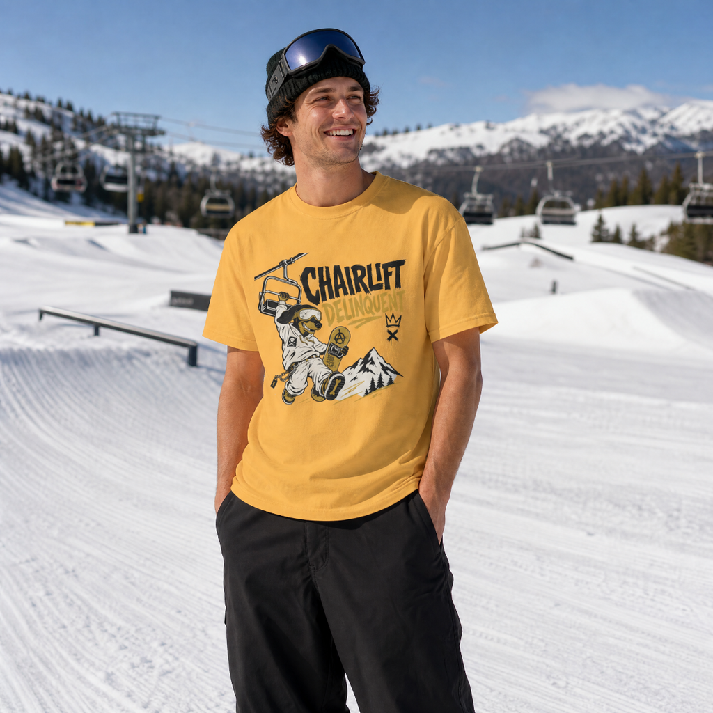 Person wearing a mustard yellow t-shirt with a graphic design in a snowy outdoor setting