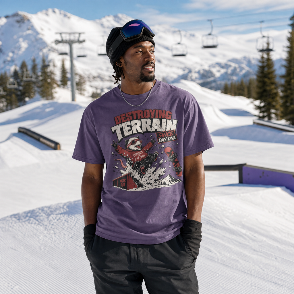 Person wearing a purple t-shirt with graphic design in a snowy mountain setting