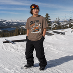Person wearing a 'Slush' t-shirt on a snowy slope with mountains in the background