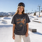 Person wearing a graphic t-shirt in a snowy outdoor setting with mountains in the background