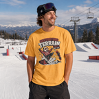 Man wearing a mustard yellow t-shirt with a graphic design in a snowy mountain setting