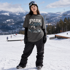 Person wearing a 'PARK RAT' t-shirt on a snowy mountain with ski lifts and trees in the background.