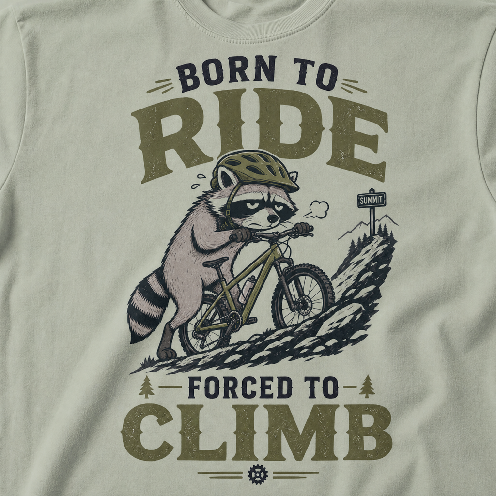 Bay green t-shirt with a graphic of a raccoon riding a bike and text 'Born to Ride, Forced to Climb'.