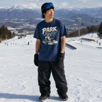 Person wearing a 'Park Rat' t-shirt on a snowy slope with mountains in the background