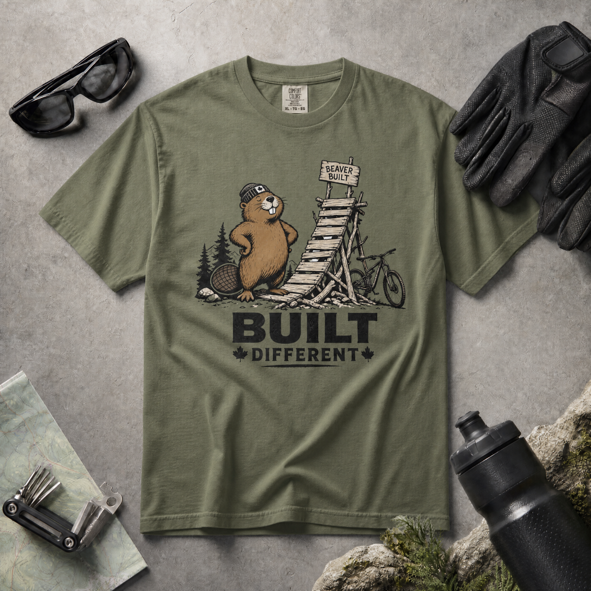 Moss green t-shirt with beaver graphic and 'Built Different' text on a white background