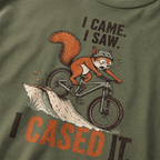 Moss green t-shirt with a graphic of a squirrel on a bike and humorous text.