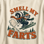 T-shirt with a skier squirrel graphic and 'Smell my Farts' text on an ivory white background