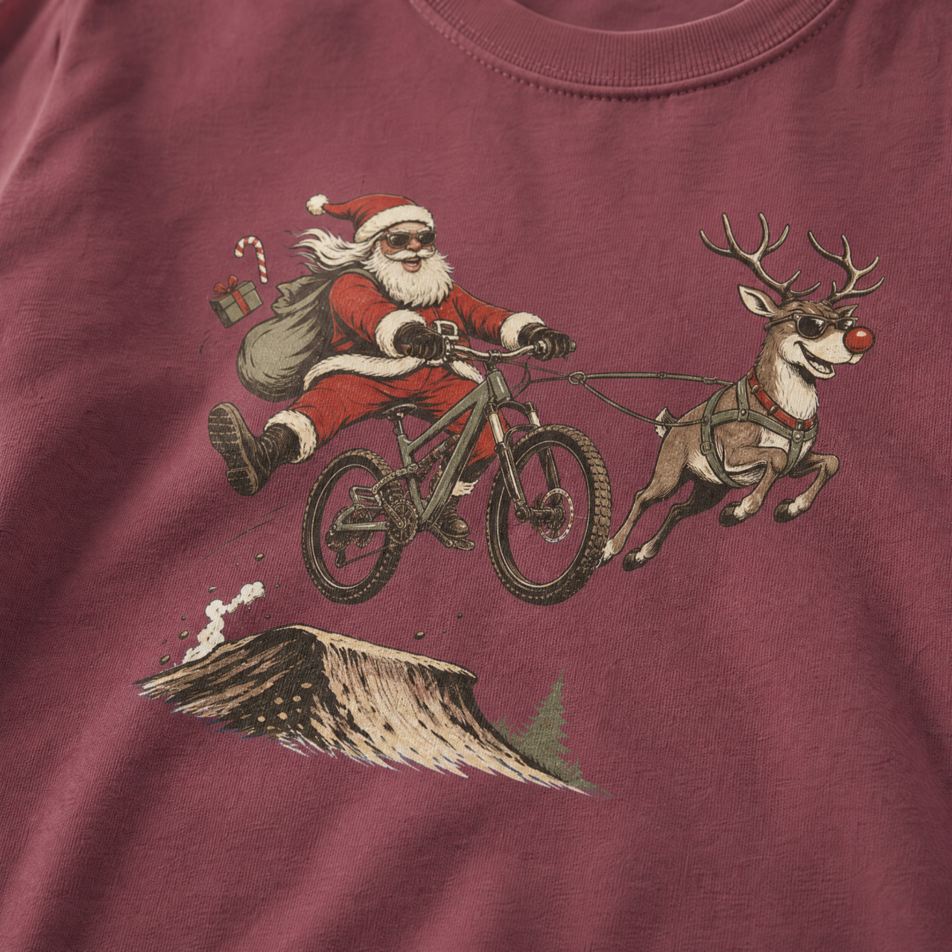 Brick red t-shirt with a graphic of Santa Claus riding a bike with a reindeer.