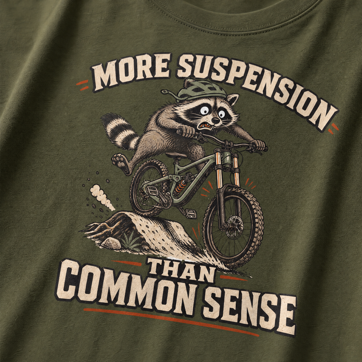 Hemp green t-shirt with a raccoon riding a bike graphic and text 'More suspension than common sense'.