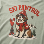 T-shirt with a dog illustration wearing skis and goggles, text 'SKI PAWTROL', and mountain and tree design on a bay green background.