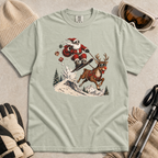 Bay green t-shirt with a graphic of Santa skiing with a reindeer, surrounded by winter accessories on a beige surface.