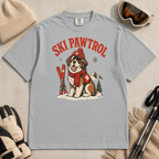 Granite gray t-shirt with a dog graphic and 'Ski Pawtrol' text, surrounded by winter accessories on a beige background.