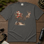 Pepper gray t-shirt with a graphic of Santa Claus riding a bike with a reindeer, on a wooden surface with outdoor gear.