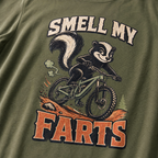 Hemp green t-shirt with a graphic of a badger on a bike and text 'Smell my farts'.