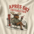 T-shirt with a moose character holding a drink and text 'Après Ski Instructor' on an ivory white background.